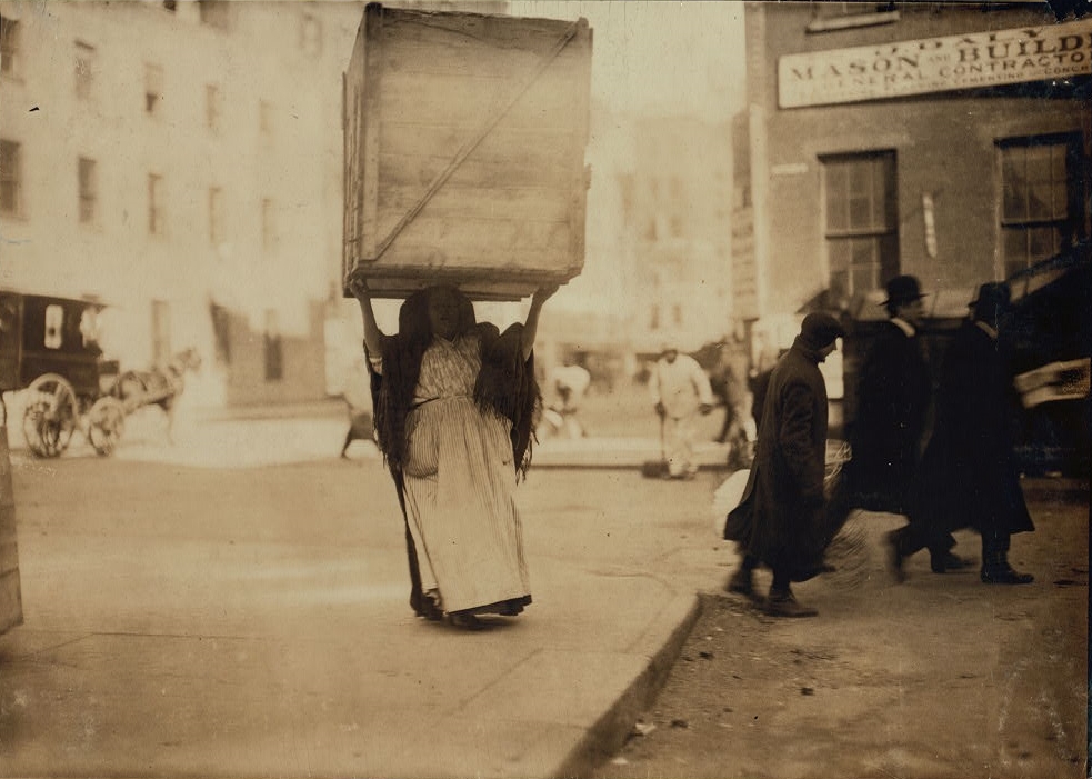 Lewis W. Hine, Italian woman carrying an enormous empty dry-goods-box for some distance along Bleeker Street, N.Y., 1912