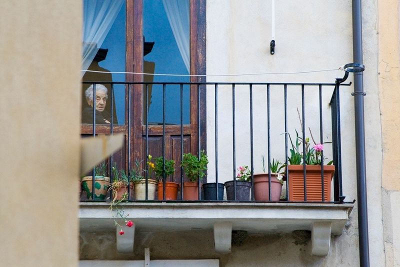 Un'anziana segue dalla finestra la processione dei Misteri Pasquali, Caulonia (Reggio Calabria)  - Ph. © Simona Tonna