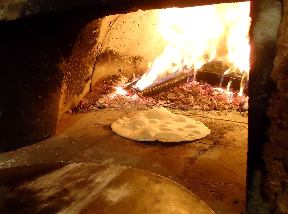 Cottura di una focaccia in un forno a legna